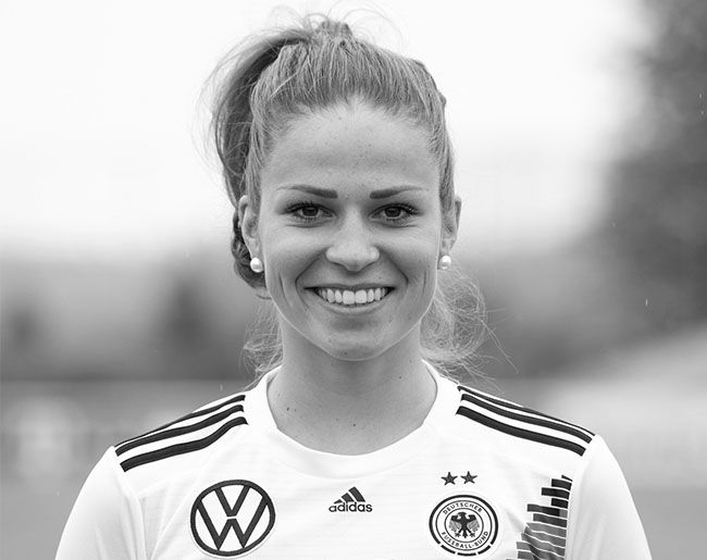 Lächelnde Fußballspielerin im Trikot der deutschen Nationalmannschaft.